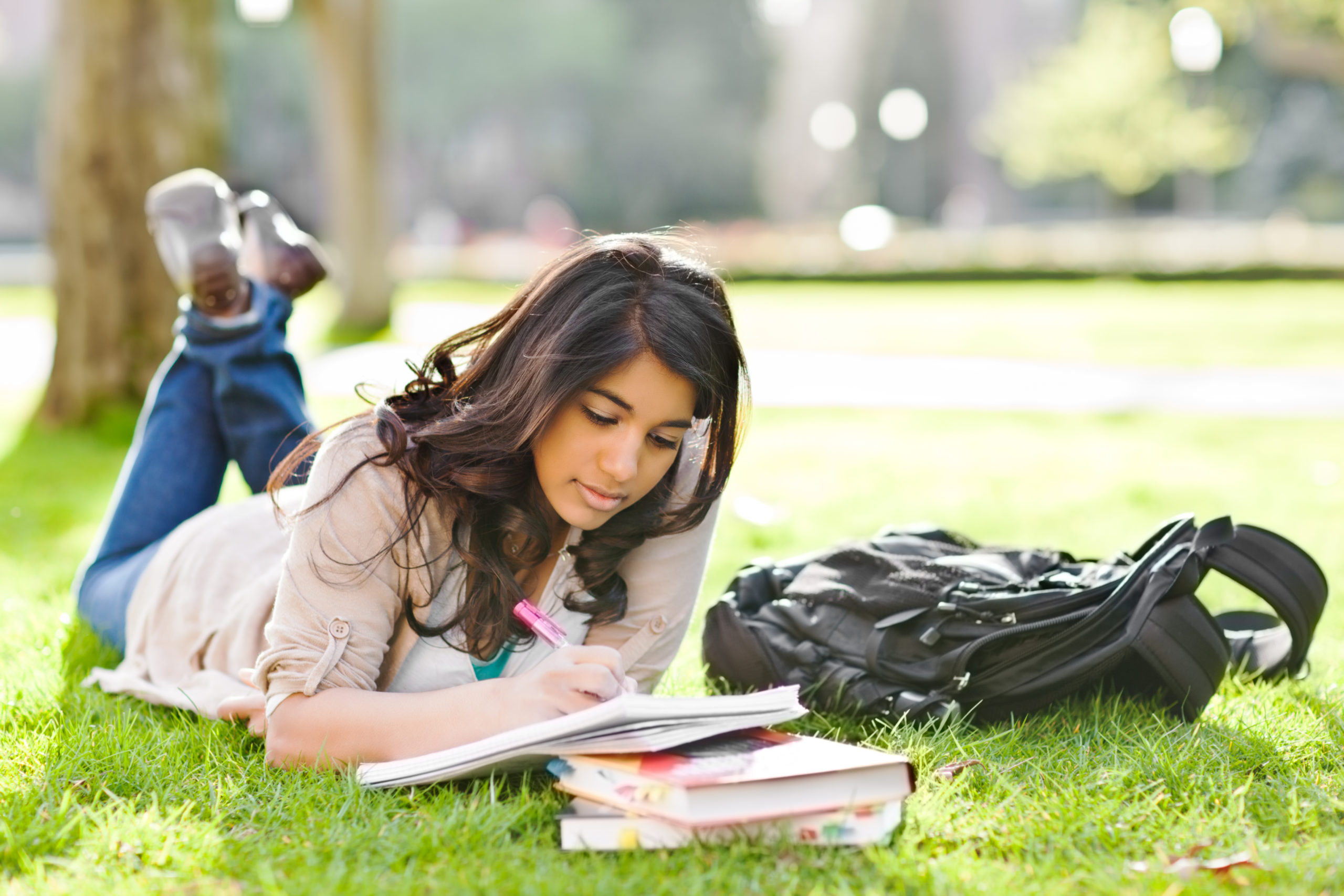 College student studying in grass.